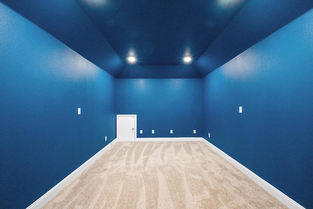 unfurnished room featuring lofted ceiling and carpet