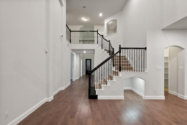 5204 Basham Ln, Mckinney, TX 75070 - foyer entrance featuring wood finished floors, stairway, arched walkways, baseboards, and a high ceiling