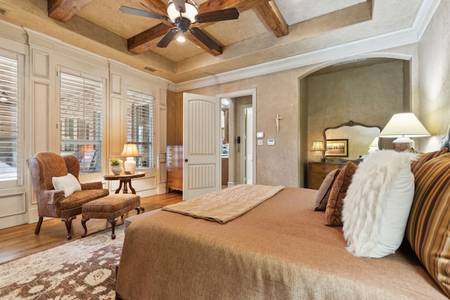 bedroom with crown molding, coffered ceiling, beam ceiling, and wood finished floors