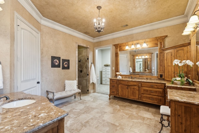 bathroom with two vanities, a sink, ornamental molding, a shower stall, and an inviting chandelier