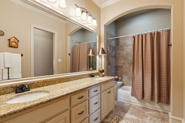 full bathroom featuring ornamental molding, shower / bath combo with shower curtain, a sink, and double vanity