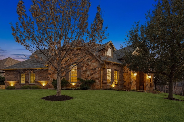 view of front of house featuring stone siding and a front lawn