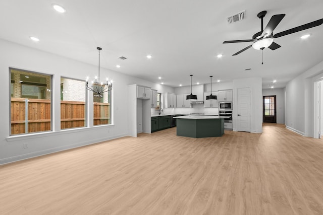 602 Lundy Ln, Mansfield, TX 76063 - kitchen with stainless steel appliances, open floor plan, a kitchen island, baseboards, and light wood-style floors