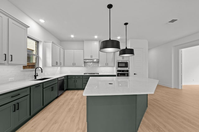 602 Lundy Ln, Mansfield, TX 76063 - kitchen featuring green cabinets, appliances with stainless steel finishes, a sink, a kitchen island, and under cabinet range hood