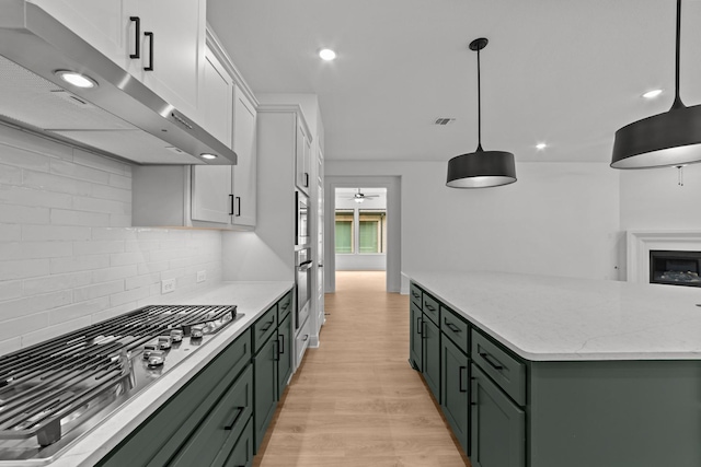 602 Lundy Ln, Mansfield, TX 76063 - kitchen featuring green cabinets, ventilation hood, stainless steel appliances, light wood-style floors, and white cabinetry