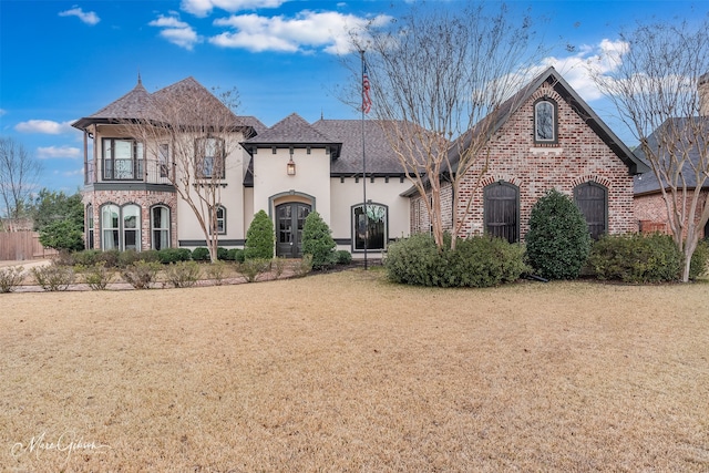 view of front of house featuring a balcony and a front yard