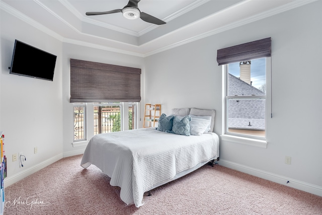 bedroom with crown molding, light carpet, ceiling fan, and a tray ceiling