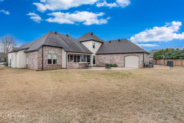 back of house featuring a yard, a garage, a patio, and central AC unit