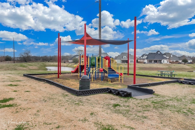 view of playground featuring a water view and a lawn