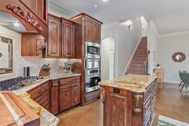 kitchen with tasteful backsplash, crown molding, a kitchen island, and appliances with stainless steel finishes