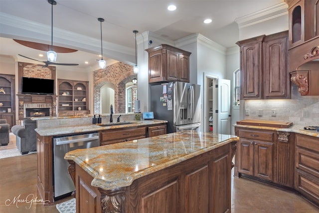 kitchen with pendant lighting, sink, ornamental molding, a center island, and stainless steel appliances