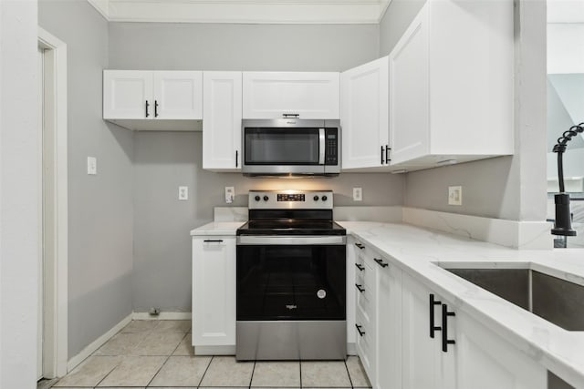 kitchen with white cabinets, appliances with stainless steel finishes, light stone countertops, and sink