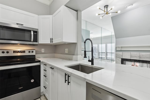 kitchen featuring sink, light stone countertops, white cabinetry, and stainless steel appliances