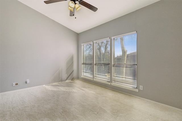 carpeted spare room featuring ceiling fan and vaulted ceiling