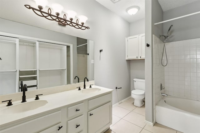 full bathroom featuring tile patterned flooring, toilet, a textured ceiling, vanity, and tiled shower / bath combo