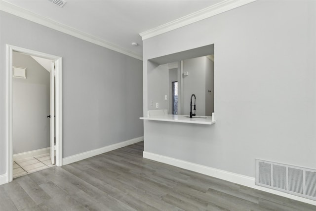 interior space featuring hardwood / wood-style flooring, ornamental molding, and sink