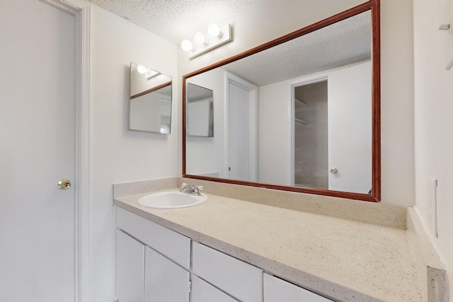 bathroom featuring a textured ceiling and vanity