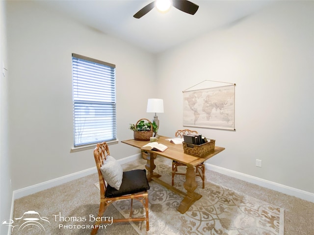 carpeted home office featuring ceiling fan