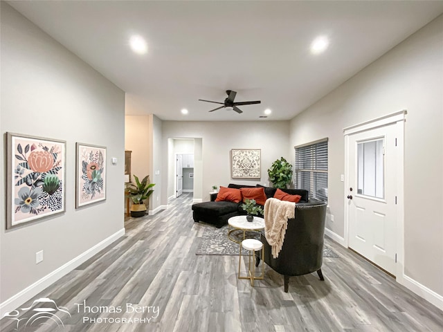 living room with ceiling fan and light hardwood / wood-style flooring