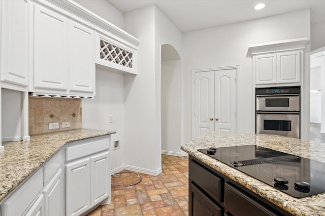 kitchen with white cabinetry, black electric cooktop, and double oven