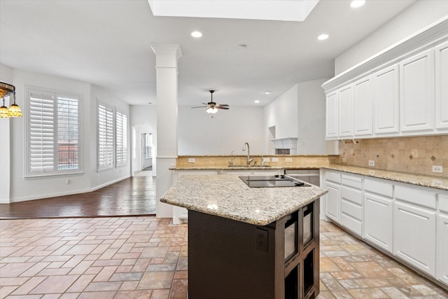 kitchen with sink, tasteful backsplash, black electric cooktop, ceiling fan, and white cabinets