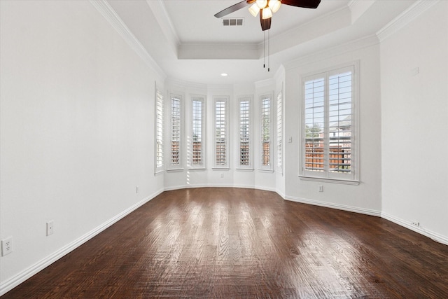 spare room with ornamental molding, dark wood-type flooring, and a tray ceiling