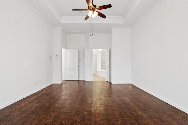 unfurnished bedroom featuring ensuite bath, ornamental molding, dark hardwood / wood-style flooring, a raised ceiling, and ceiling fan