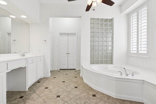 bathroom featuring ceiling fan, a tub to relax in, vanity, and tile patterned flooring