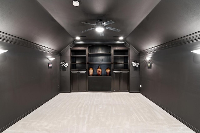 carpeted home theater with ornamental molding, lofted ceiling, and ceiling fan