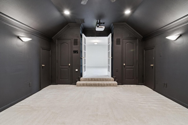 home theater room with crown molding and lofted ceiling