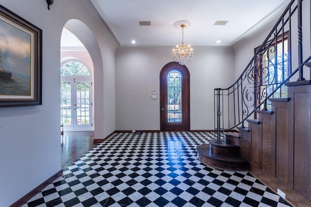 foyer entrance featuring crown molding, a notable chandelier, and french doors