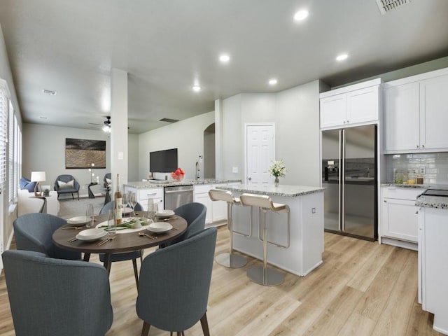 kitchen featuring white cabinetry, appliances with stainless steel finishes, a center island, and kitchen peninsula