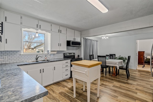 kitchen featuring tasteful backsplash, sink, white cabinets, and light wood-type flooring