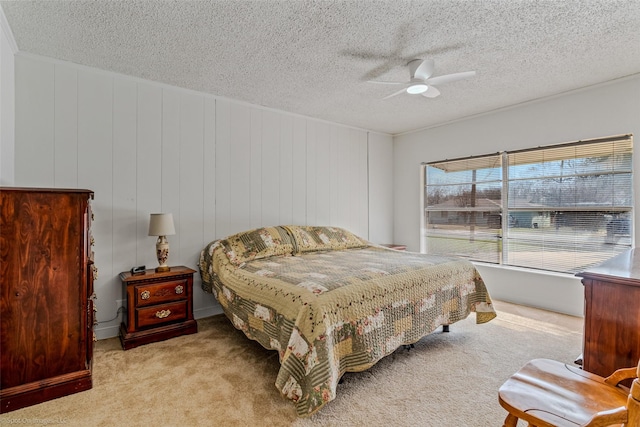 bedroom featuring light colored carpet, a textured ceiling, and ceiling fan