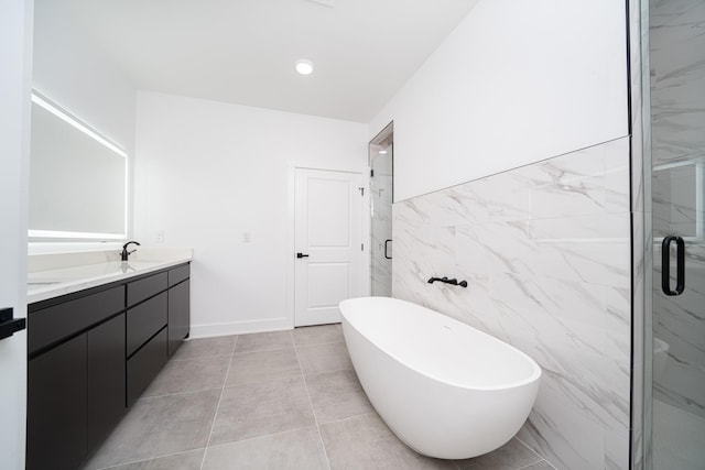 bathroom with independent shower and bath, vanity, and tile walls