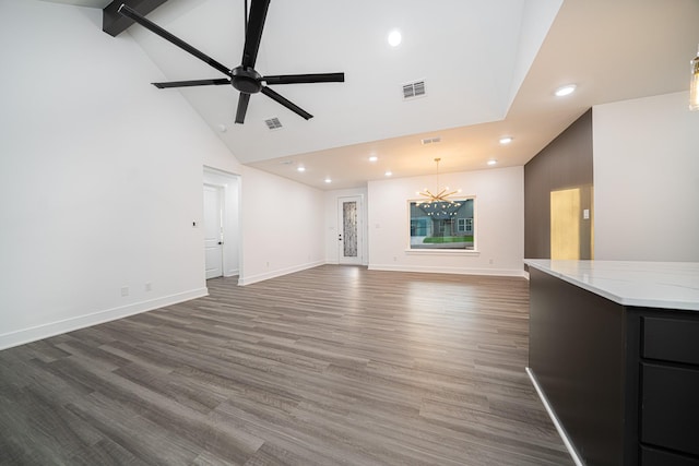 unfurnished living room featuring beamed ceiling, dark hardwood / wood-style floors, ceiling fan with notable chandelier, and high vaulted ceiling