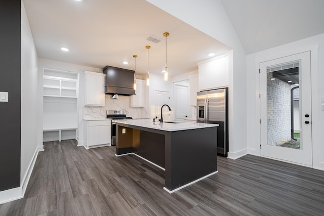 kitchen featuring pendant lighting, stainless steel appliances, tasteful backsplash, an island with sink, and white cabinets