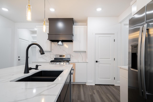 kitchen featuring premium range hood, sink, white cabinets, hanging light fixtures, and stainless steel appliances