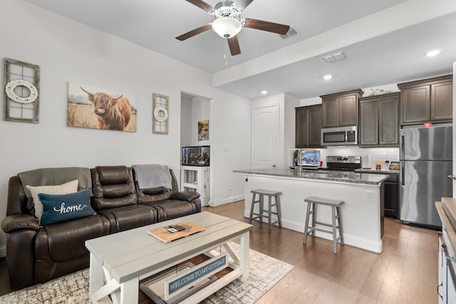 living room featuring hardwood / wood-style flooring and ceiling fan