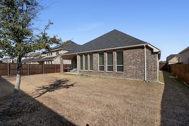 rear view of property with a yard