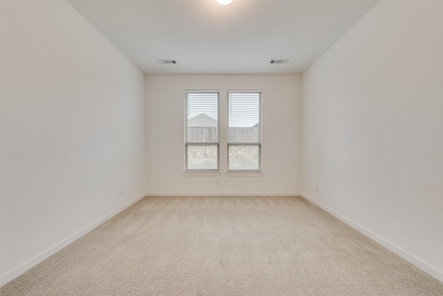 spare room featuring light colored carpet