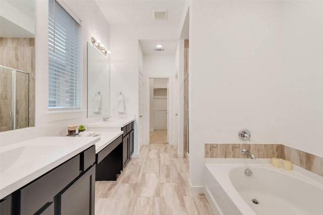 bathroom with shower with separate bathtub and vanity