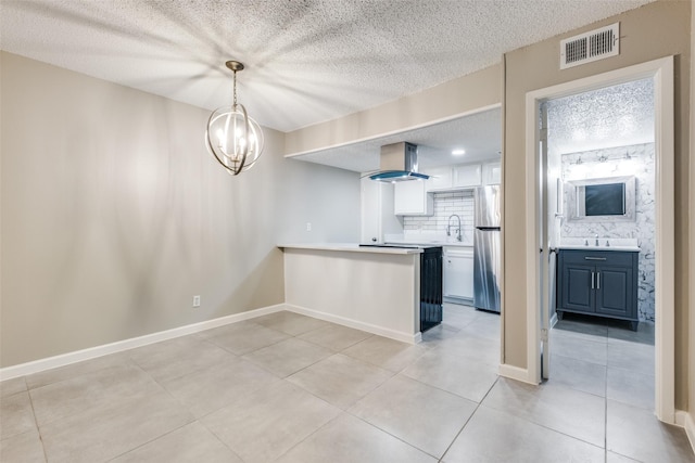 kitchen featuring pendant lighting, sink, stainless steel refrigerator, white cabinetry, and island exhaust hood