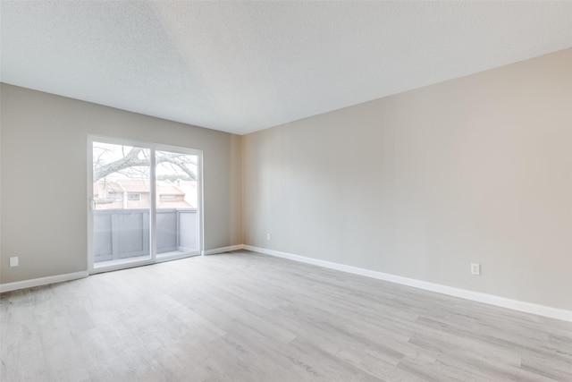 empty room featuring a textured ceiling and light wood-type flooring