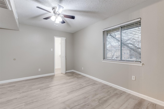 spare room with ceiling fan, a textured ceiling, and light wood-type flooring