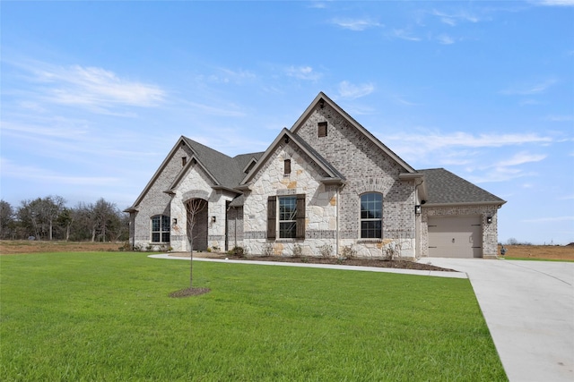 french country inspired facade with concrete driveway, brick siding, a front lawn, and roof with shingles