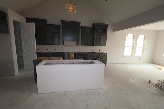 kitchen featuring a center island and high vaulted ceiling