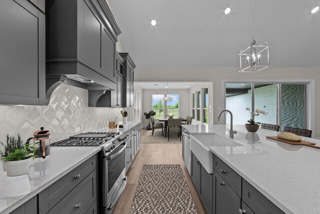 11529 Wulstone Rd, Fort Worth, TX 76052 - kitchen featuring stainless steel appliances, a chandelier, a sink, light wood-style flooring, and light stone counters