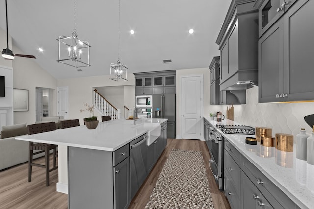 11529 Wulstone Rd, Fort Worth, TX 76052 - kitchen with appliances with stainless steel finishes, open floor plan, gray cabinets, tasteful backsplash, and wood finished floors