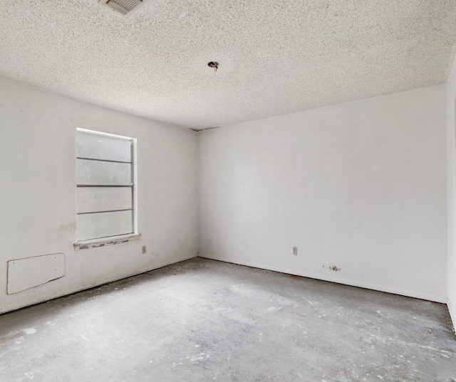 spare room with concrete flooring and a textured ceiling